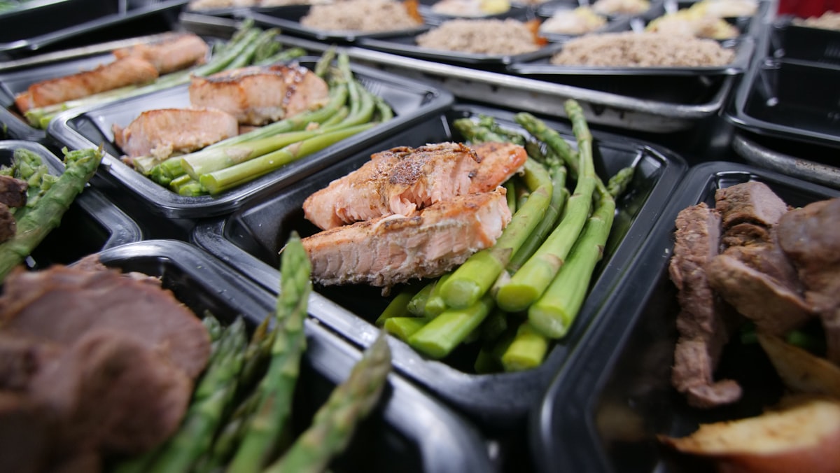 Glass meal prep containers organized in refrigerator with labels